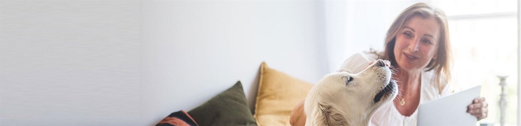 Woman sitting on the bed with her dog