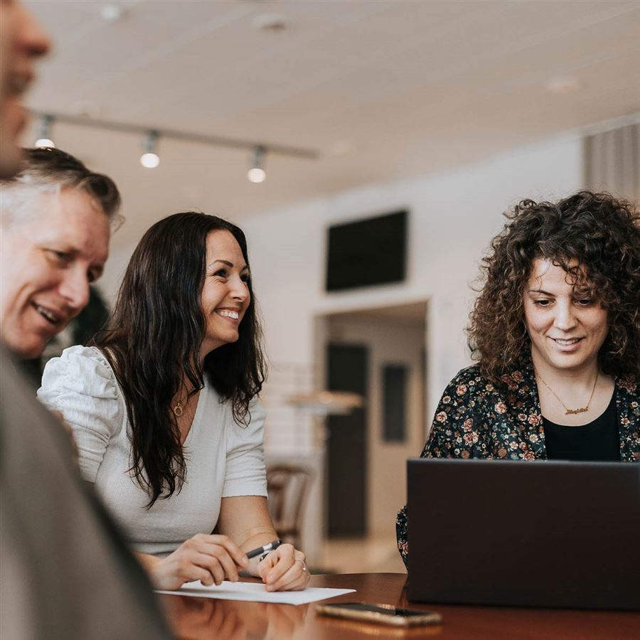 Colleagues working and smiling while sat at table