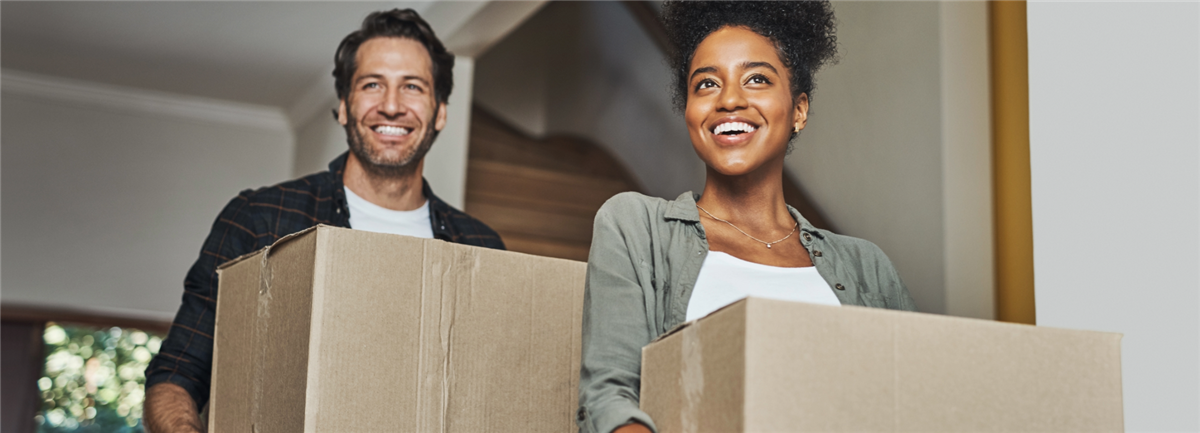 Couple moving house, holding boxes